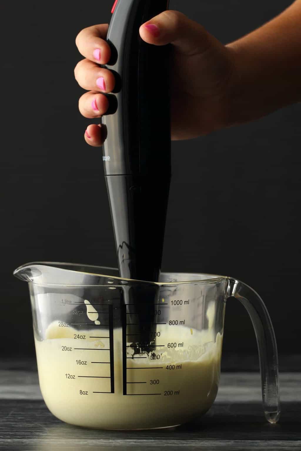 Vegan Mayonnaise freshly blended in a measuring jug with an immersion blender. 