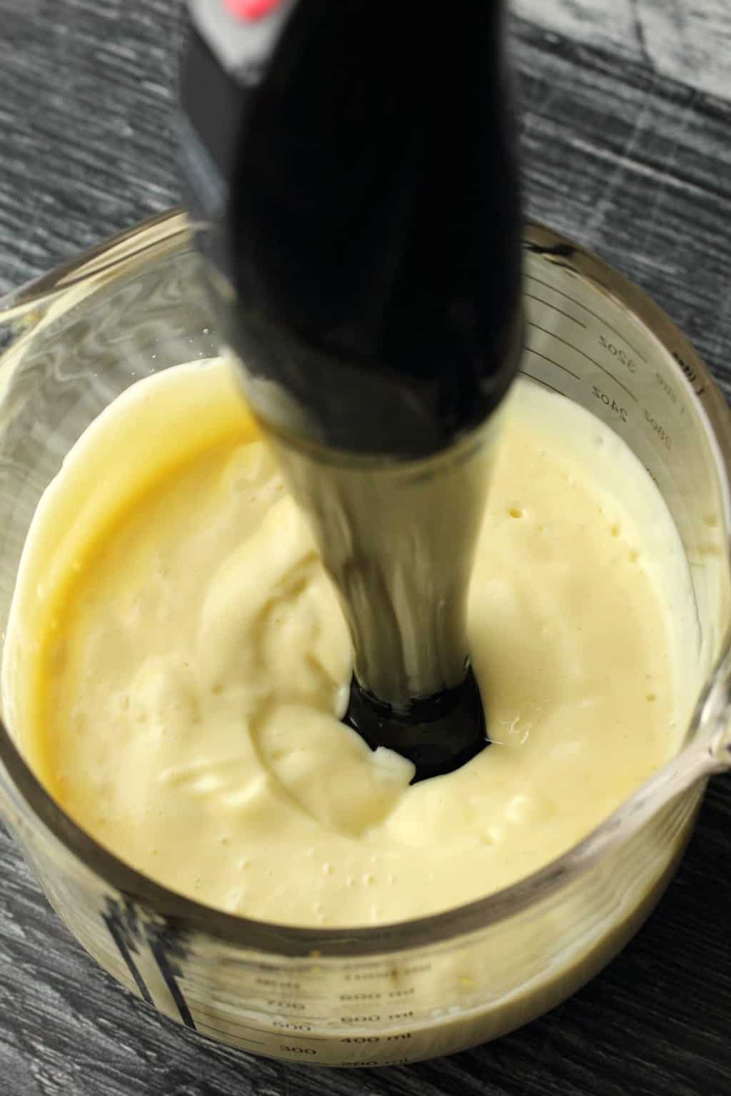 Overhead shot of vegan mayonnaise freshly blended with an immersion blender. 