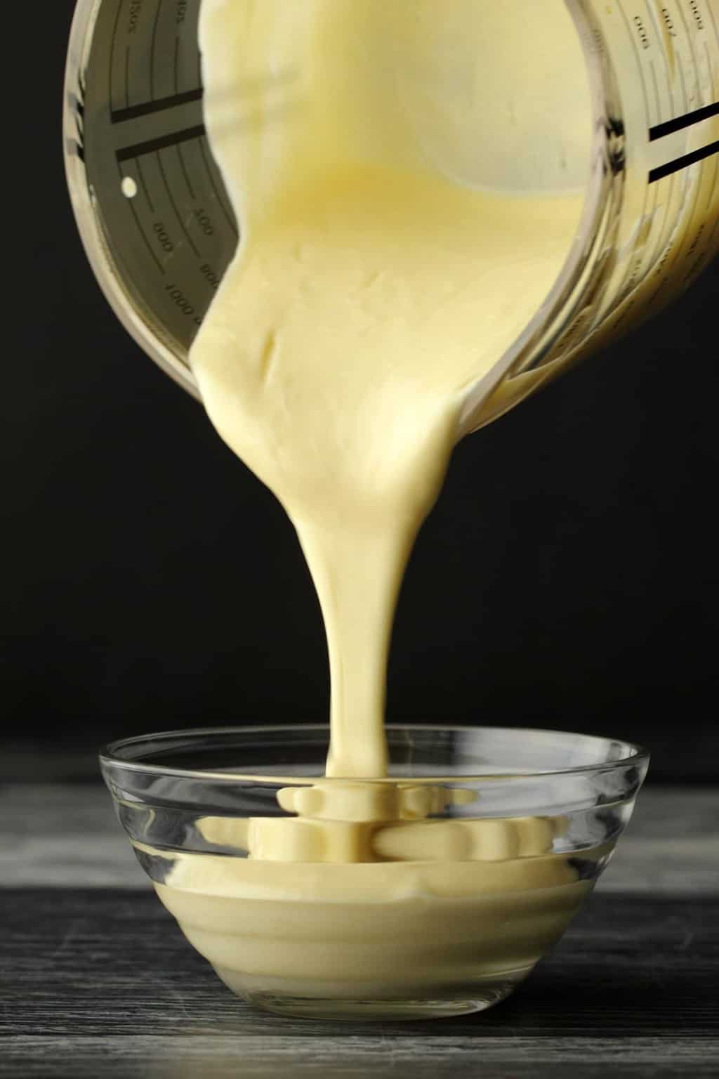 Vegan Mayonnaise pouring into a glass bowl. 