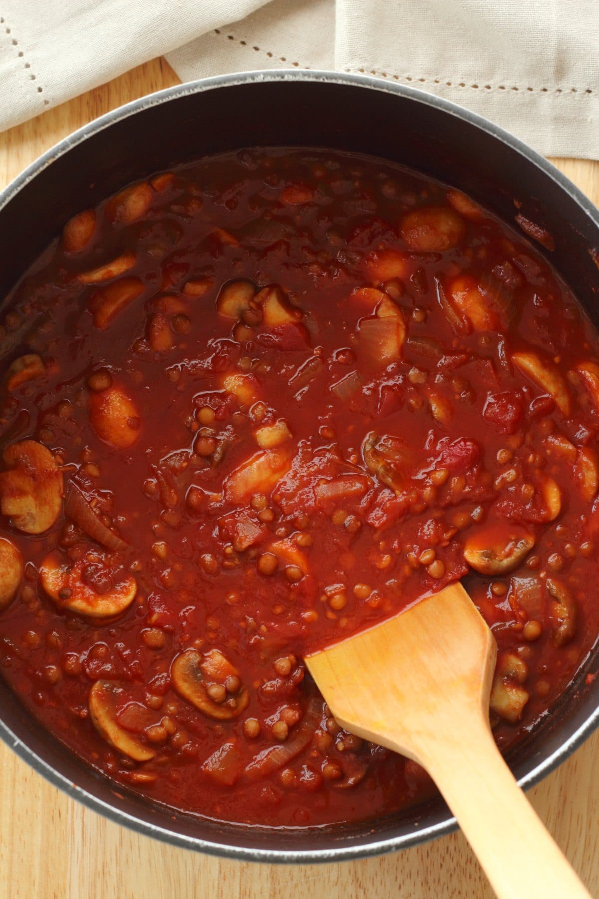 Vegan bolognese sauce in a pot with a wooden spoon. 
