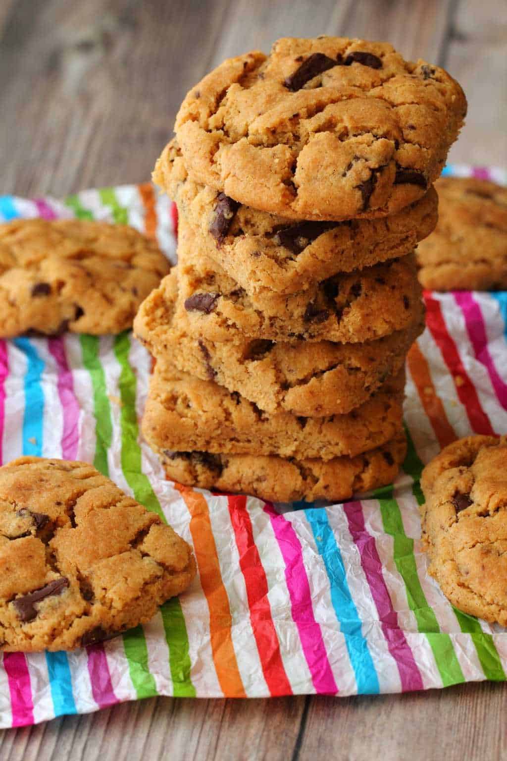 Vegan Peanut Butter Chocolate Chip Cookies in a stack on colorful paper. 