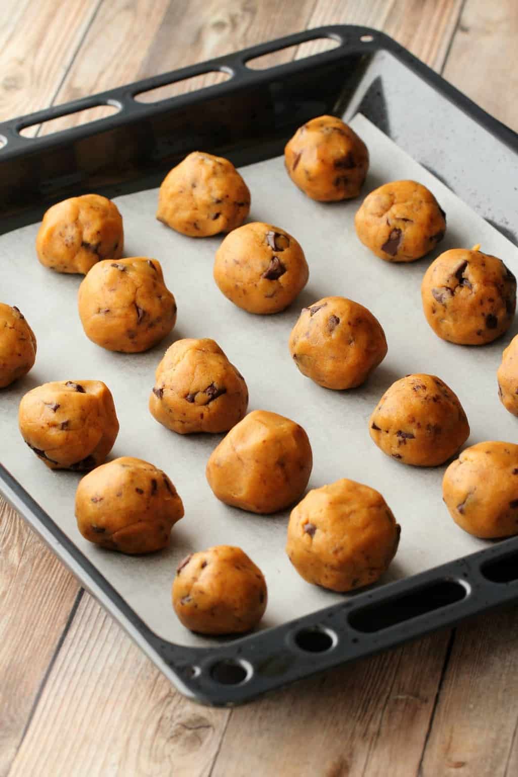 Vegan Peanut Butter Chocolate Chip Cookies rolled into balls on a baking tray and ready to go into the oven. 