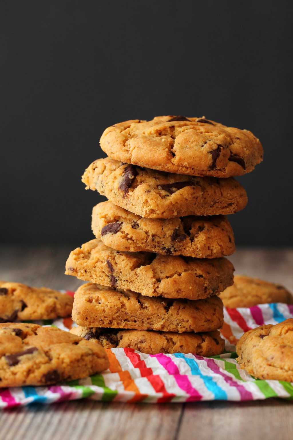 Vegan Peanut Butter Chocolate Chip Cookies in a stack against a dark background.