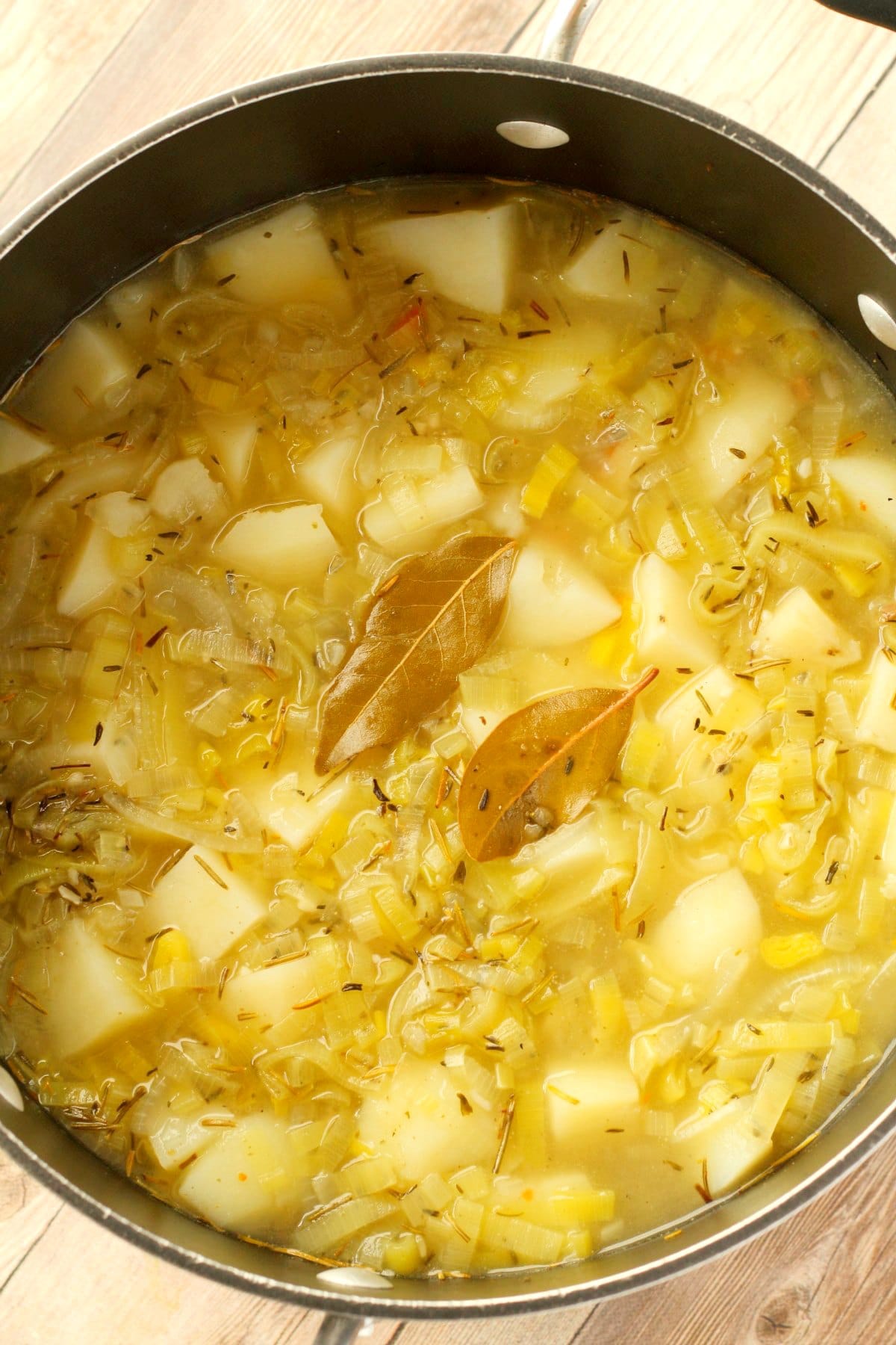 Chopped potatoes, bay leave and vegetable stock added to pot.
