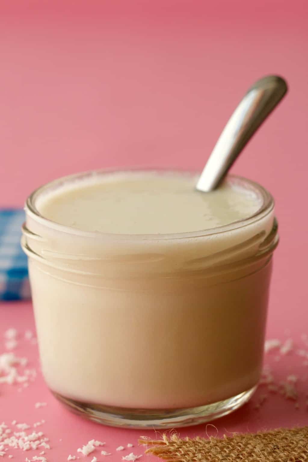 Coconut butter in a glass jar with a spoon. 