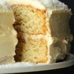 Vegan coconut cake on a white cake stand.