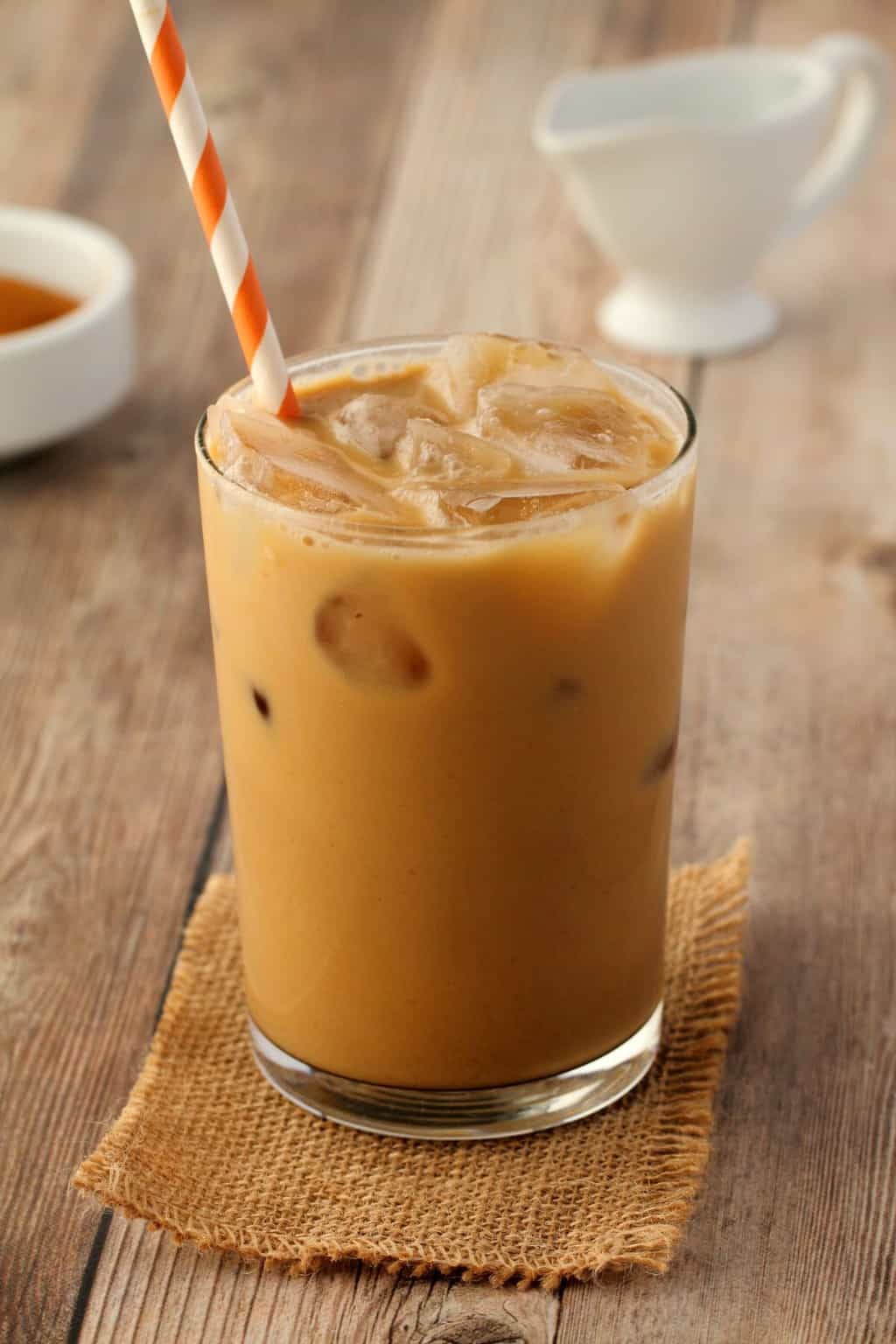 Vegan Iced Coffee in a glass with an orange and white straw. 