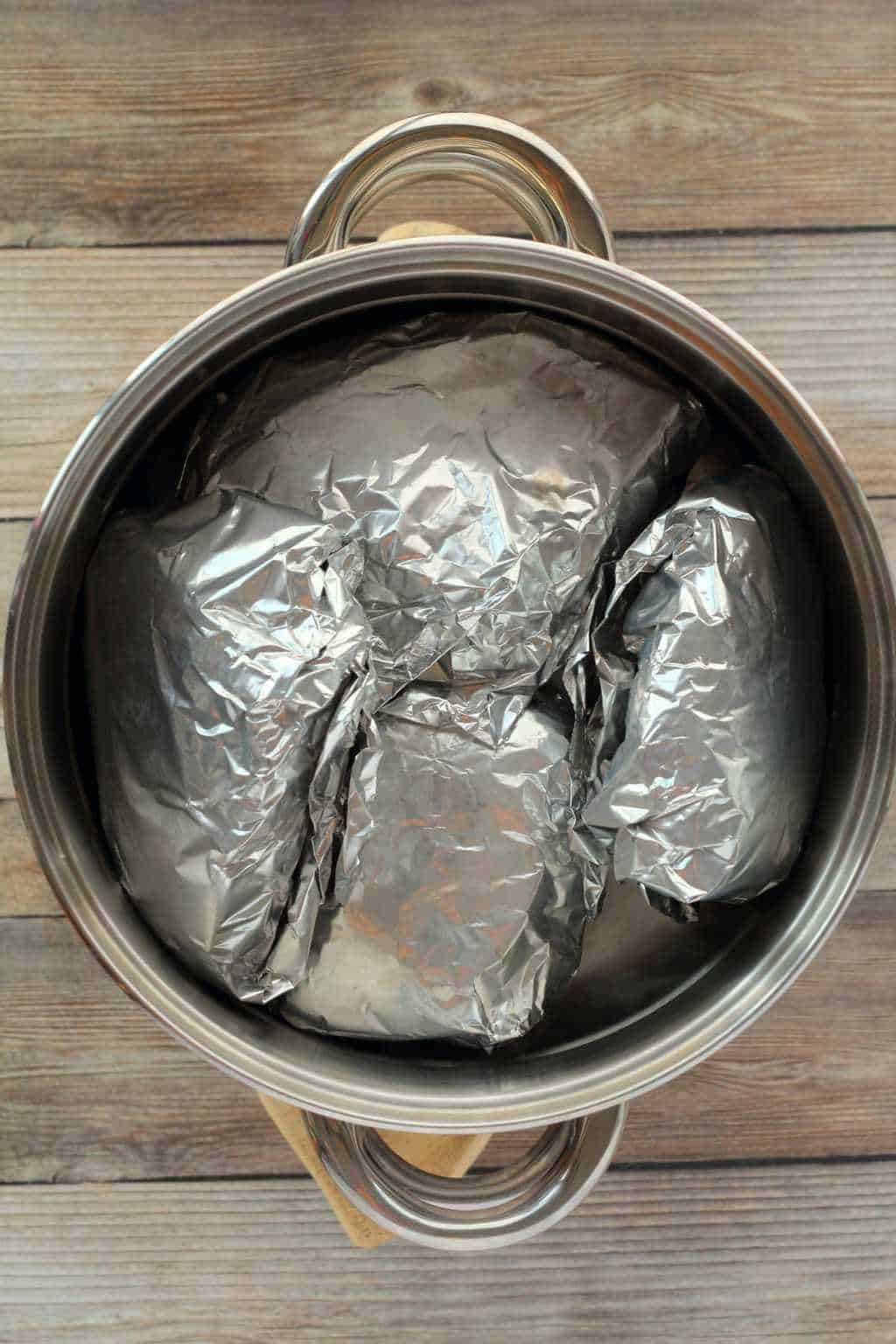 Vegan Steaks wrapped in tinfoil in a steamer basket. 