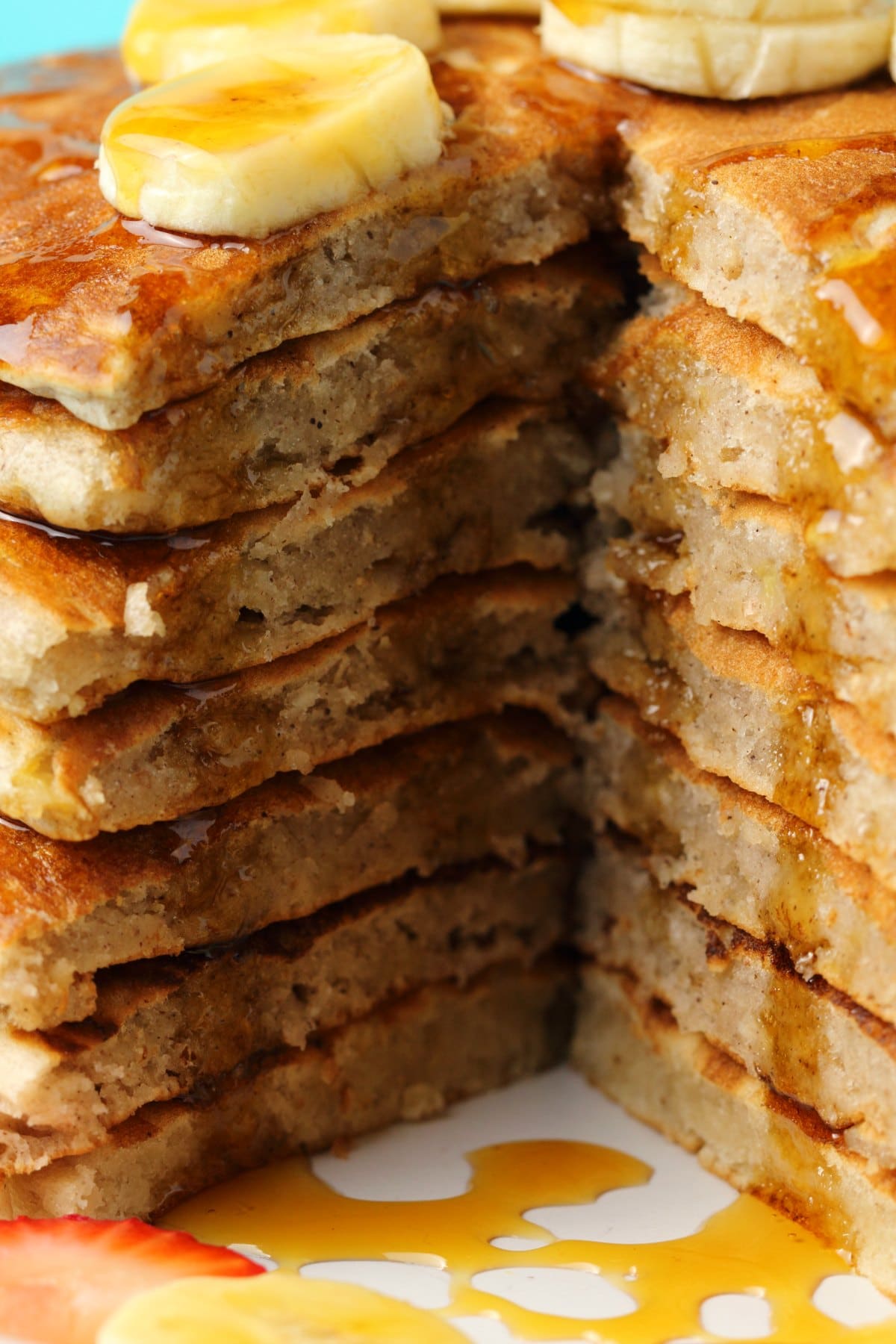 A stack of vegan banana pancakes with a slice cut out to show the centers. 