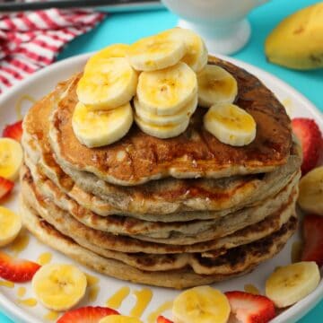Vegan banana pancakes stacked up on a white plate.