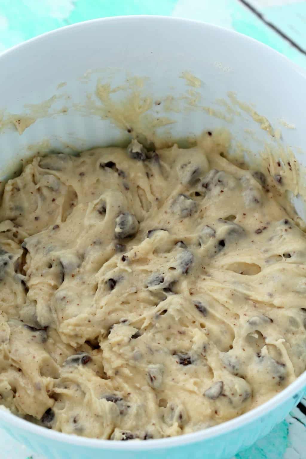 Mixing the batter for vegan chocolate chip muffins in a blue and white mixing bowl. 