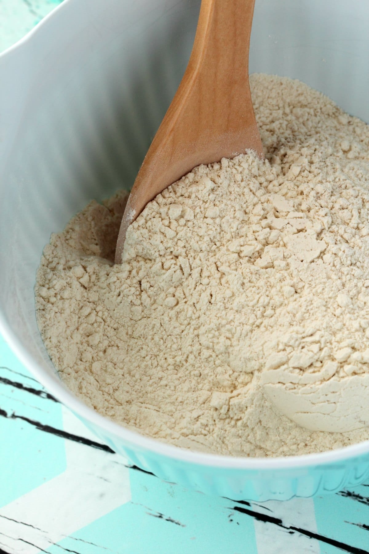 Flour, salt and yeast in a mixing bowl with a wooden spoon. 