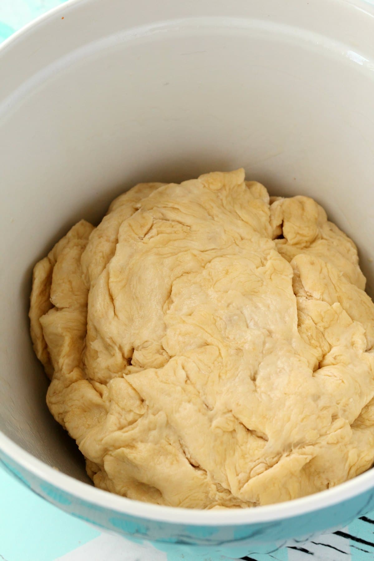 A ball of dough for vegan naan, in a blue and white mixing bowl. 