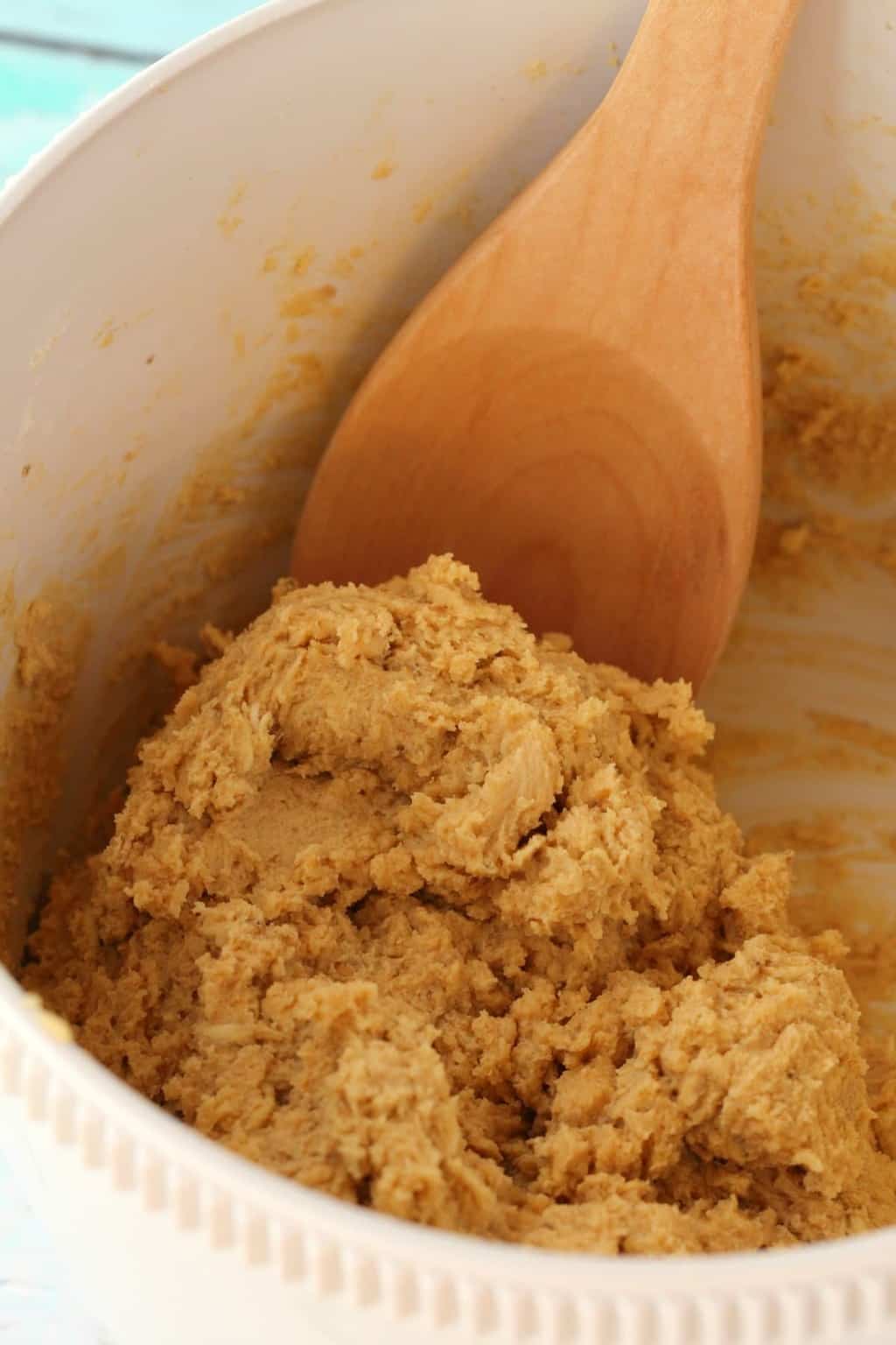 Cookie dough for vegan peanut butter oatmeal cookies in a mixing bowl with a wooden spoon. 
