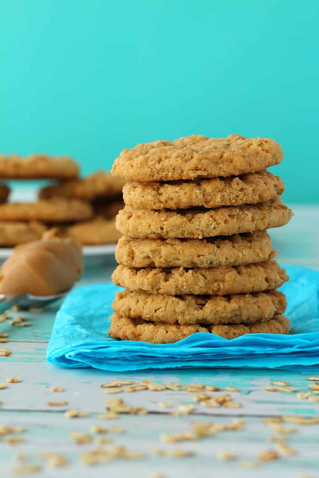 Vegan Peanut Butter Oatmeal Cookies in a stack against a blue background. 