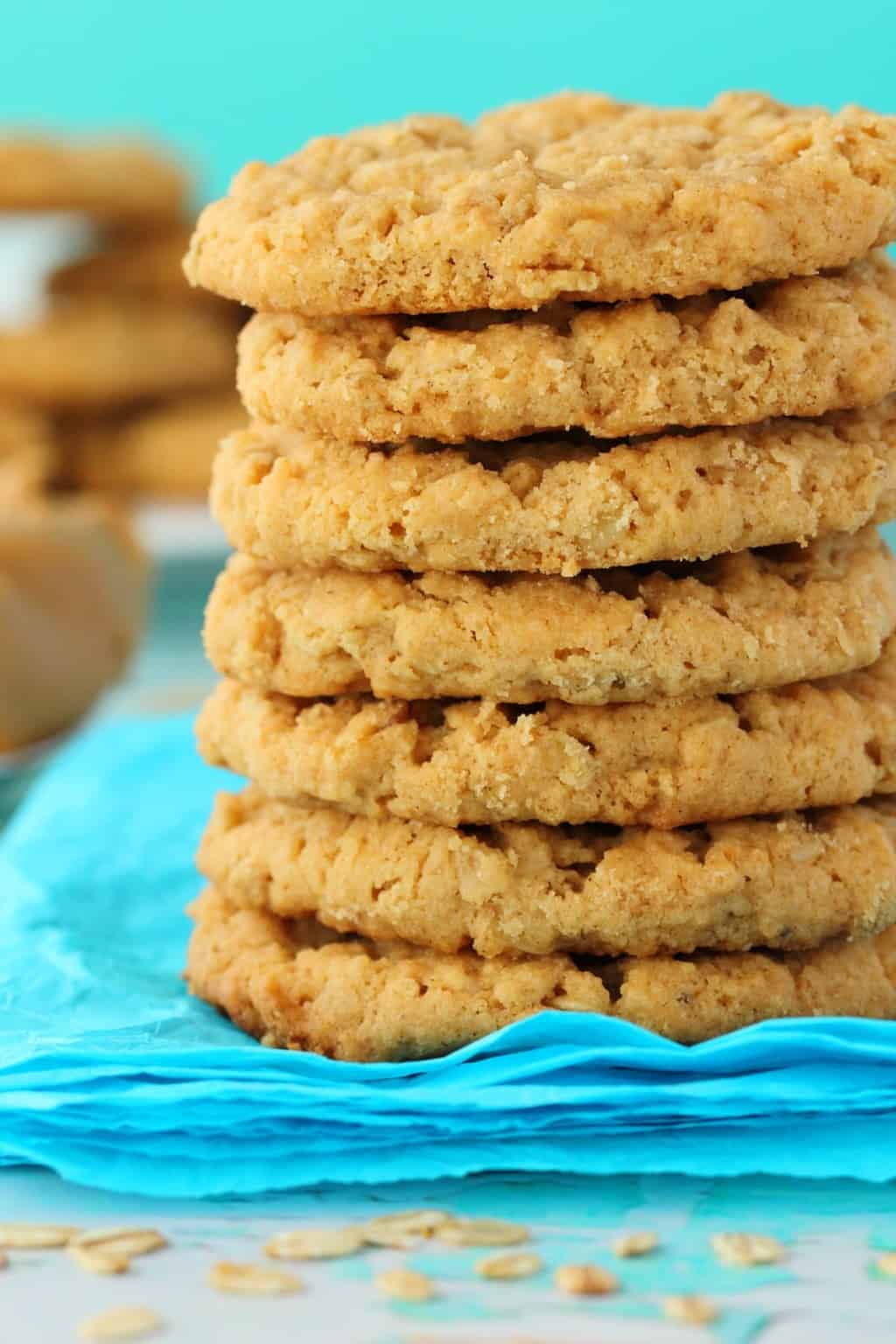 Vegan Peanut Butter Oatmeal Cookies in a stack, with a blue background. 