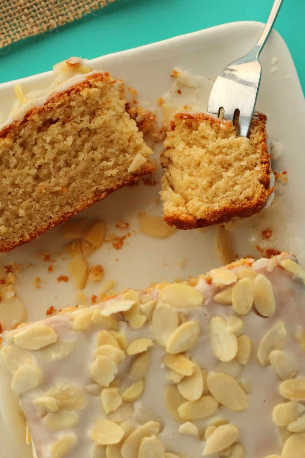 A slice of pound cake on a white plate with a cake fork. 