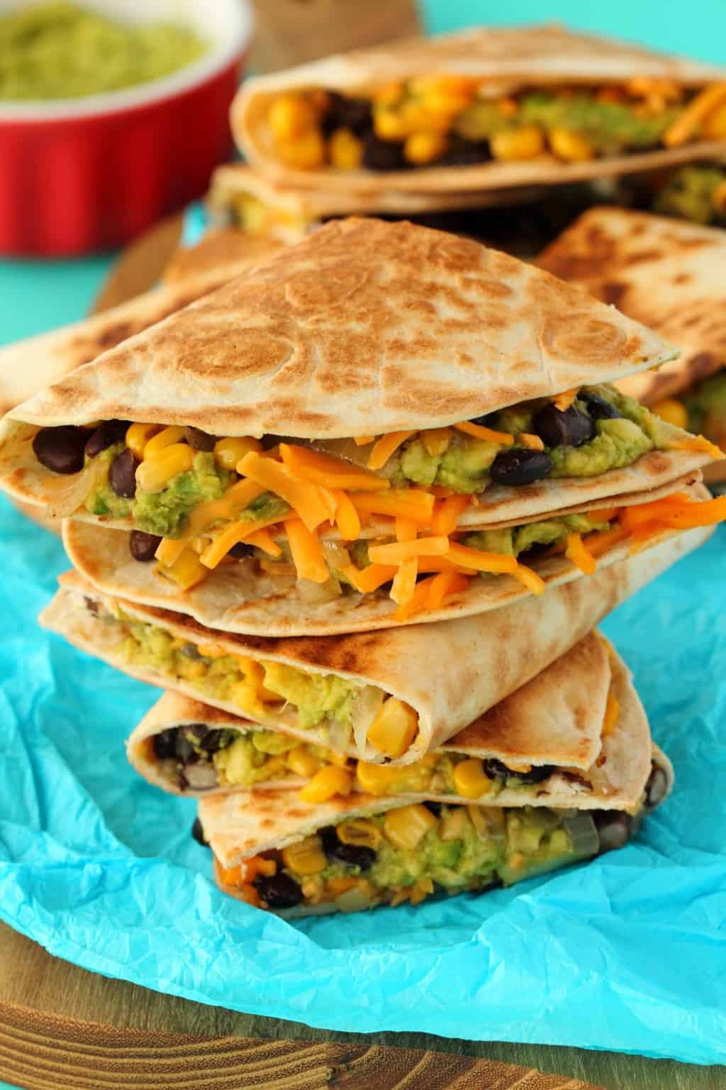 Vegan Quesadillas in a stack on blue paper. 