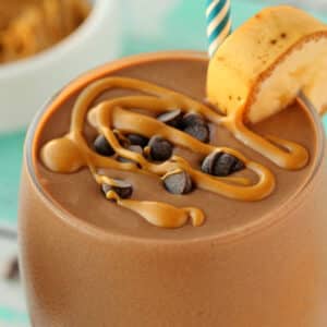 Chocolate peanut butter smoothie topped with melted peanut butter and vegan chocolate chips.