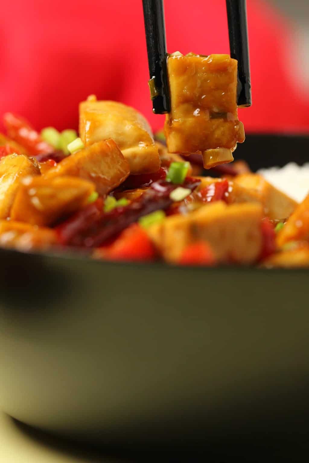 Kung pao tofu served in a wok with chopsticks. 