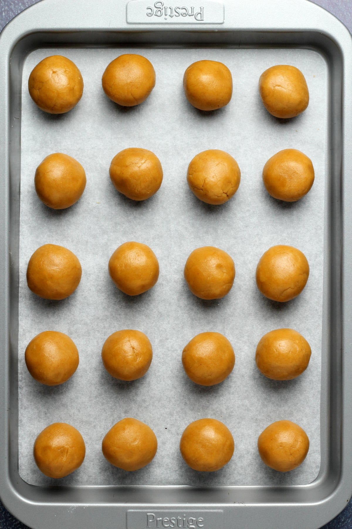 Vegan peanut butter balls on a parchment lined tray. 