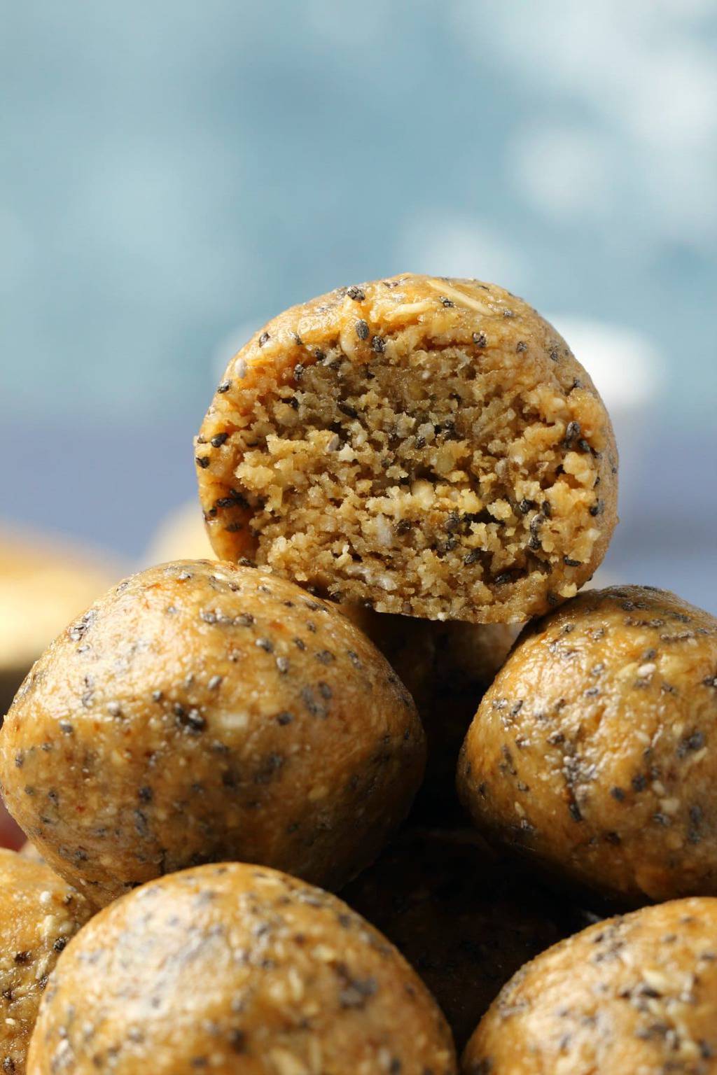Stack of vegan energy balls with the top one cut in half to show the center. 