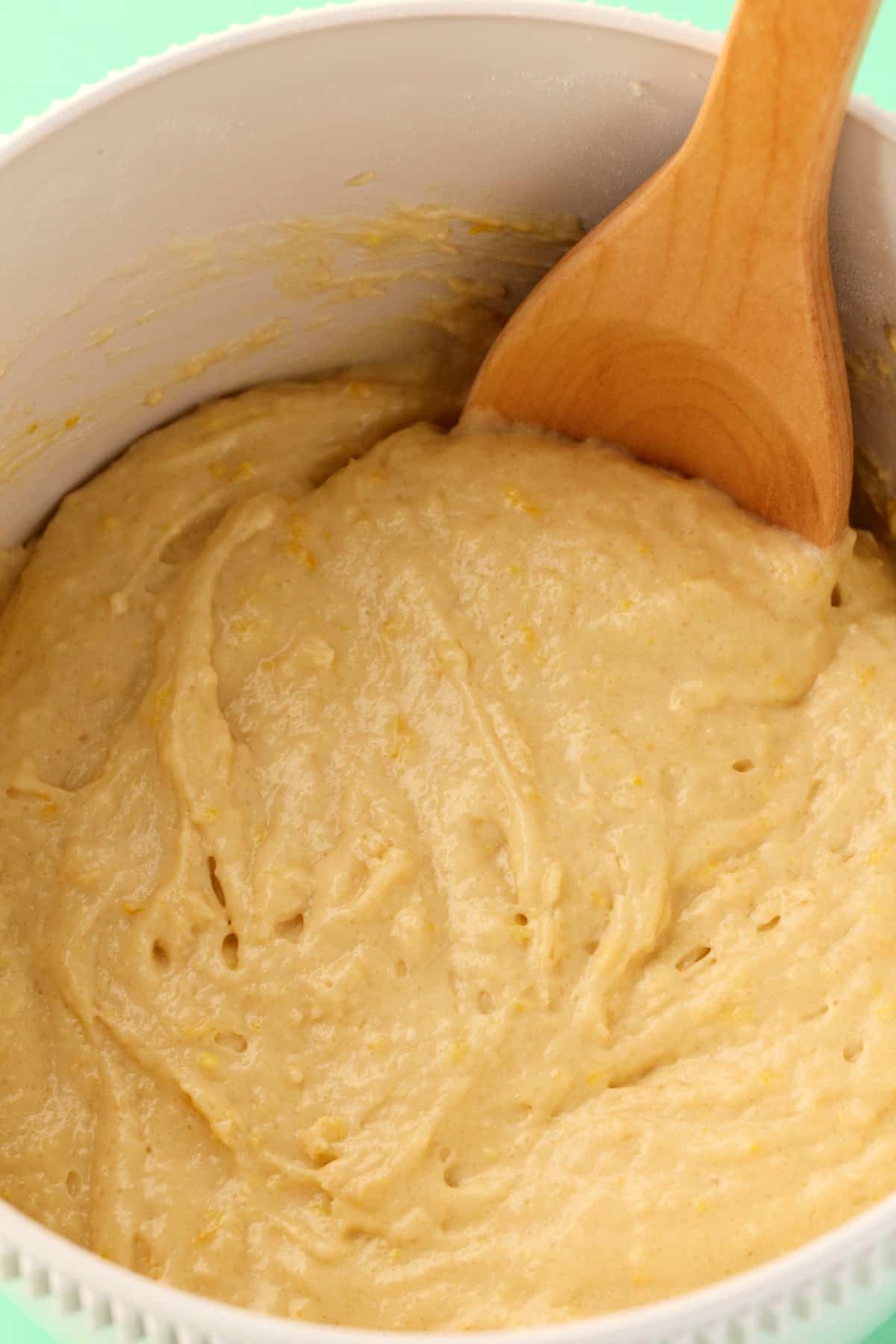 Batter in a mixing bowl with a wooden spoon. 