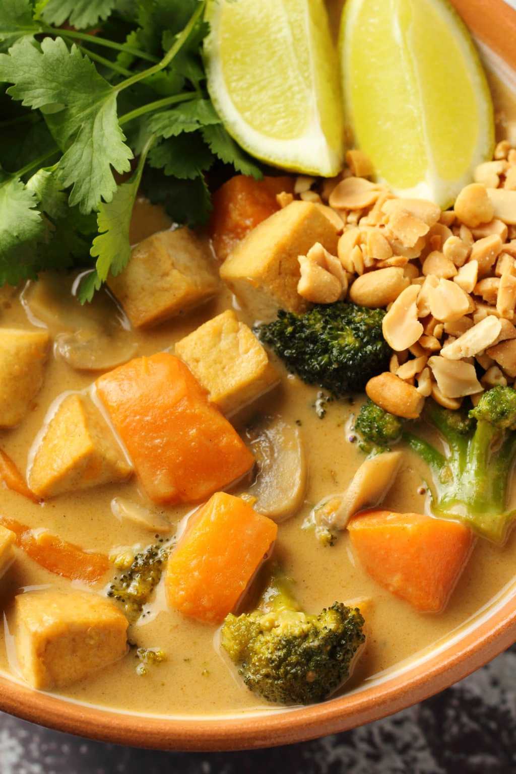 Vegan massaman curry topped with crushed peanuts, fresh cilantro and wedges of lime. 