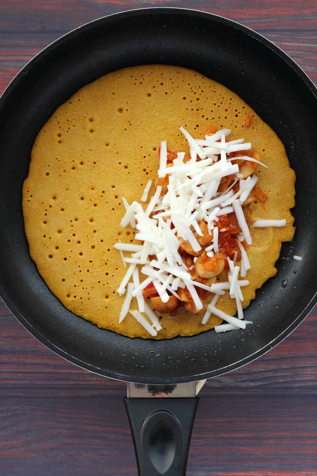 Vegan omelette cooking in a frying pan. 