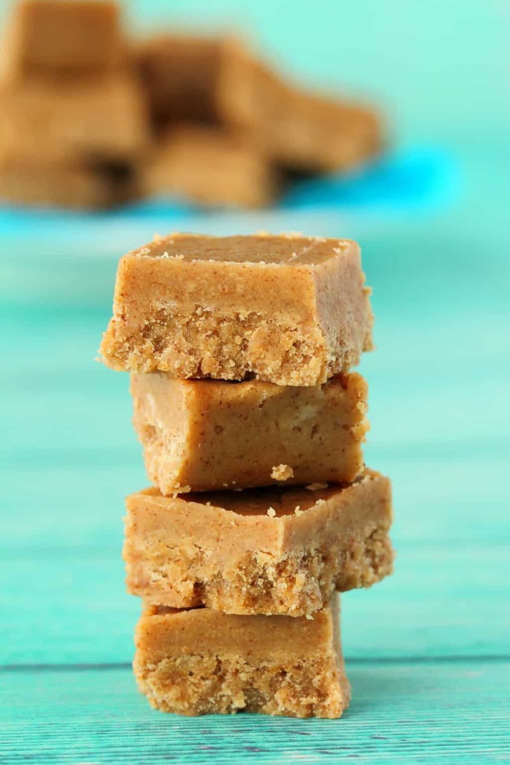 Vegan almond butter fudge in a stack against a blue background. 