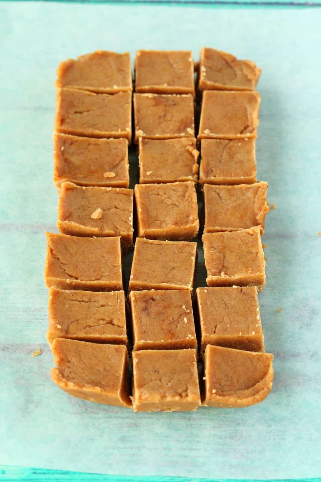Vegan almond butter fudge cut into squares on parchment paper. 
