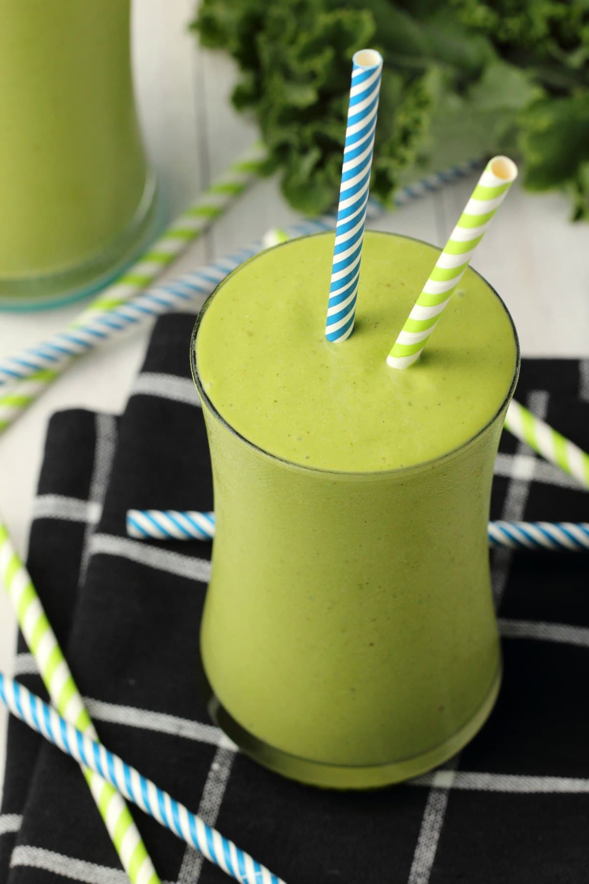 Kale Smoothie in a glass with striped straws. 