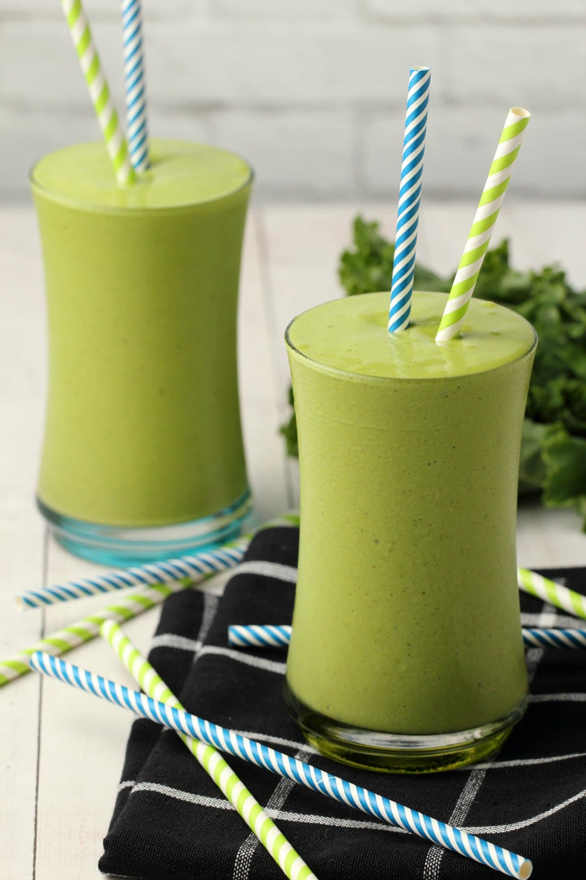 Kale Smoothie in glasses with striped straws. 