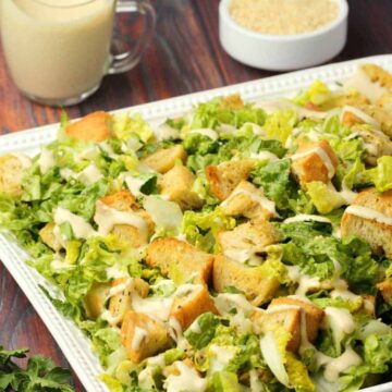 Vegan caesar salad in a white serving dish.