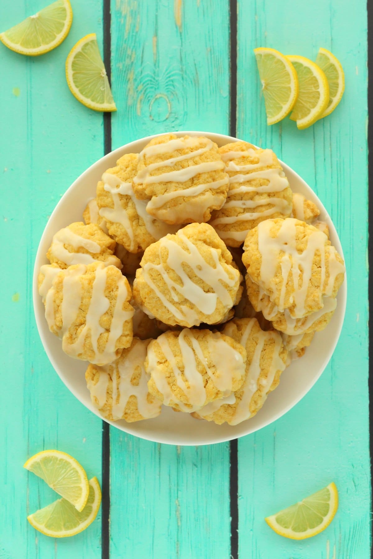 Vegan lemon cookies stacked up on a white plate. 