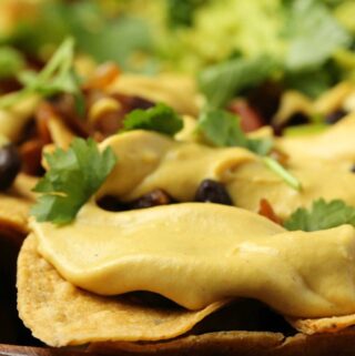 Vegan nacho cheese drizzled over tortilla chips