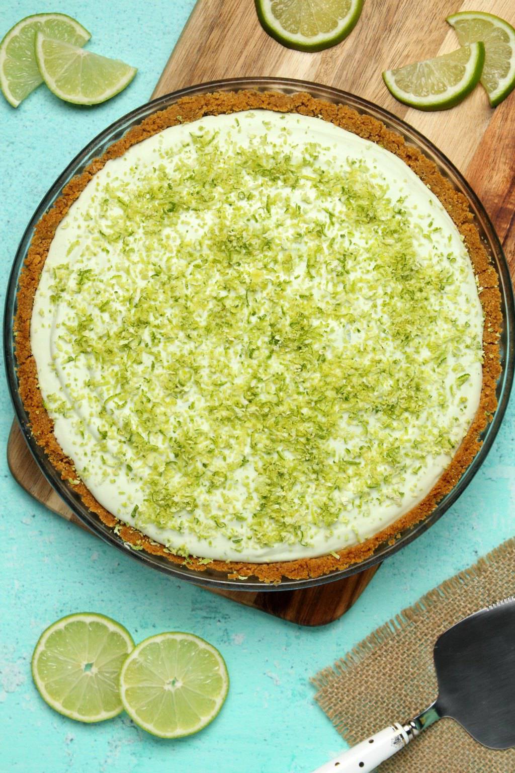 Vegan key lime pie topped with lime zest in a glass pie dish. 