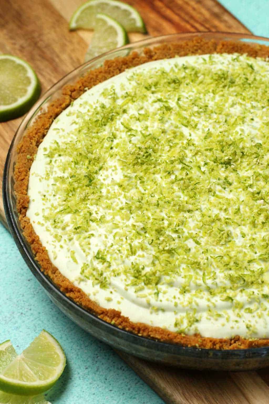 Vegan key lime pie topped with lime zest in a glass dish. 