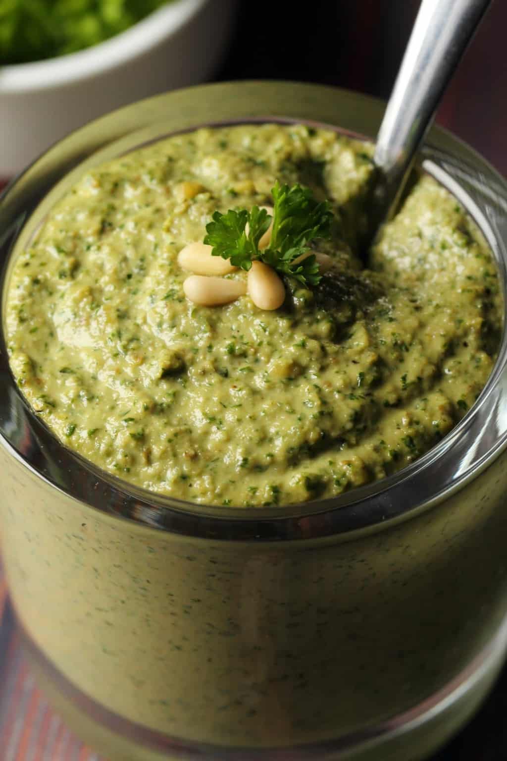 Vegan pesto in a glass jar with a spoon. 