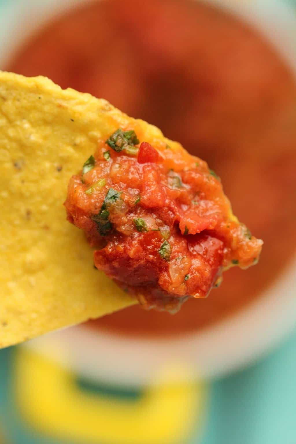 A tortilla chip with homemade salsa on top. 