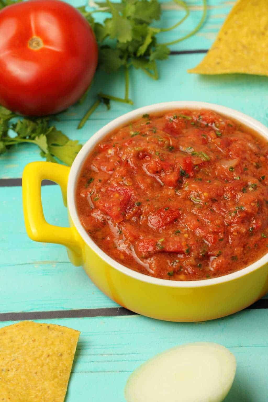 Homemade salsa in a yellow and white glass dish. 