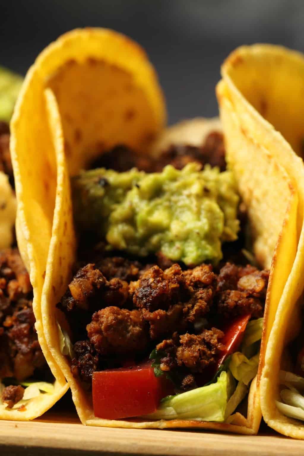 Vegan taco meat in tacos with lettuce, salsa and guacamole. 