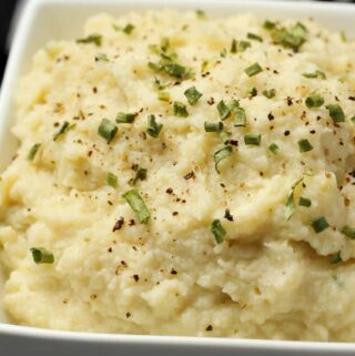 Vegan cauliflower mashed potatoes in a white bowl.
