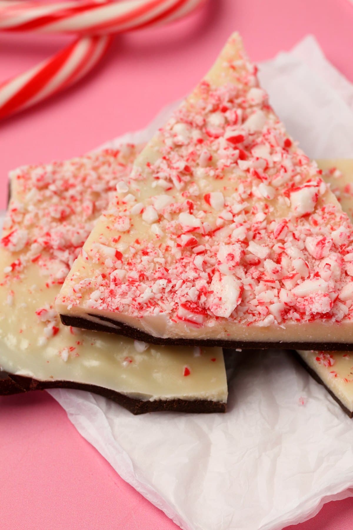 Vegan peppermint bark stacked up on top of white tissue paper. 