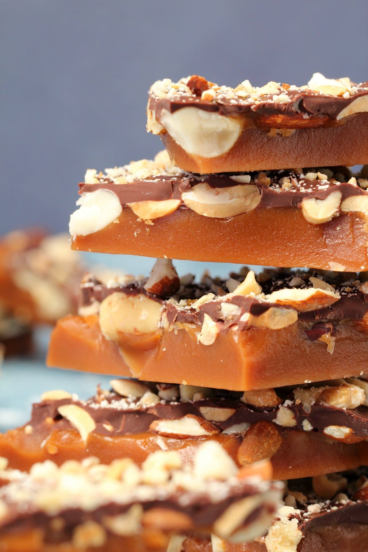 Vegan toffee topped with mixed nuts and vegan chocolate in a stack. 
