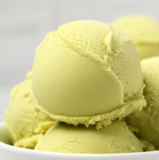 Vegan avocado ice cream scoops in a white bowl.