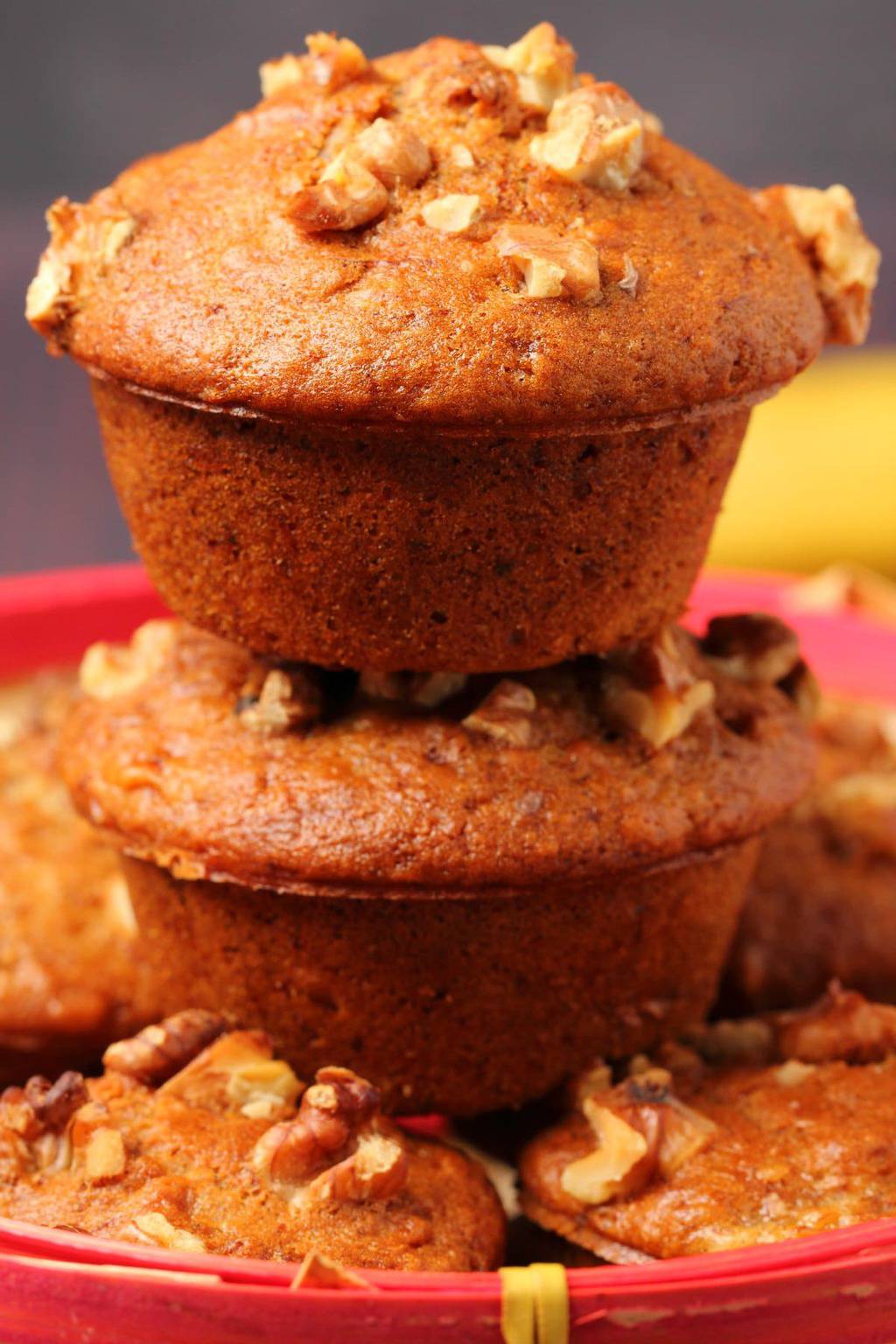 Vegan banana muffins stacked up in a woven basket. 