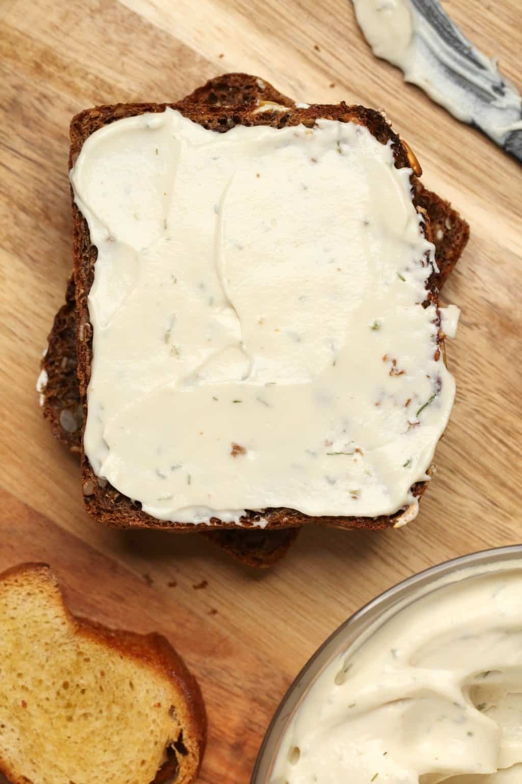 Vegan cream cheese spread on a slice of whole wheat bread. 