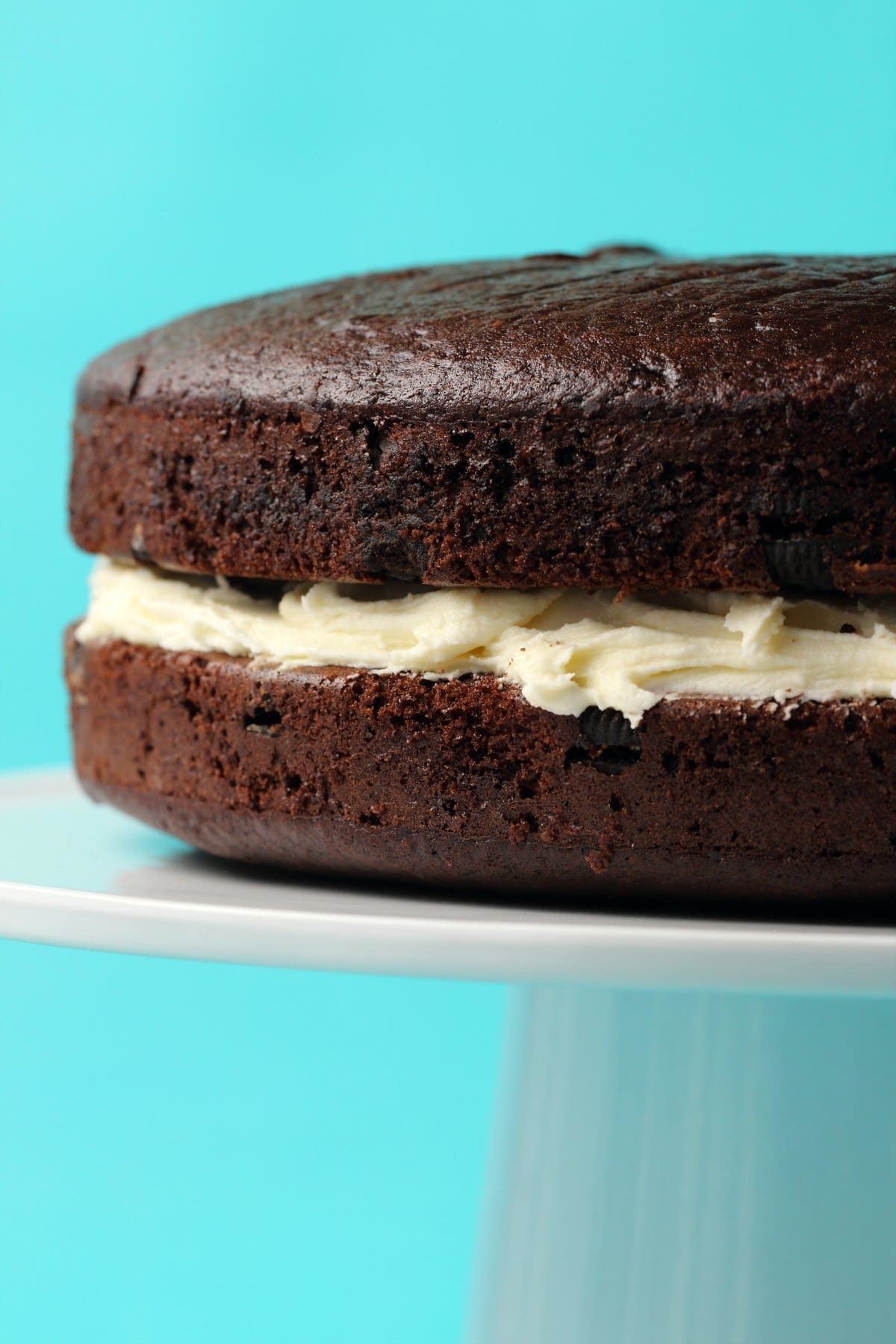 Vegan oreo cake with vanilla frosting in the middle.