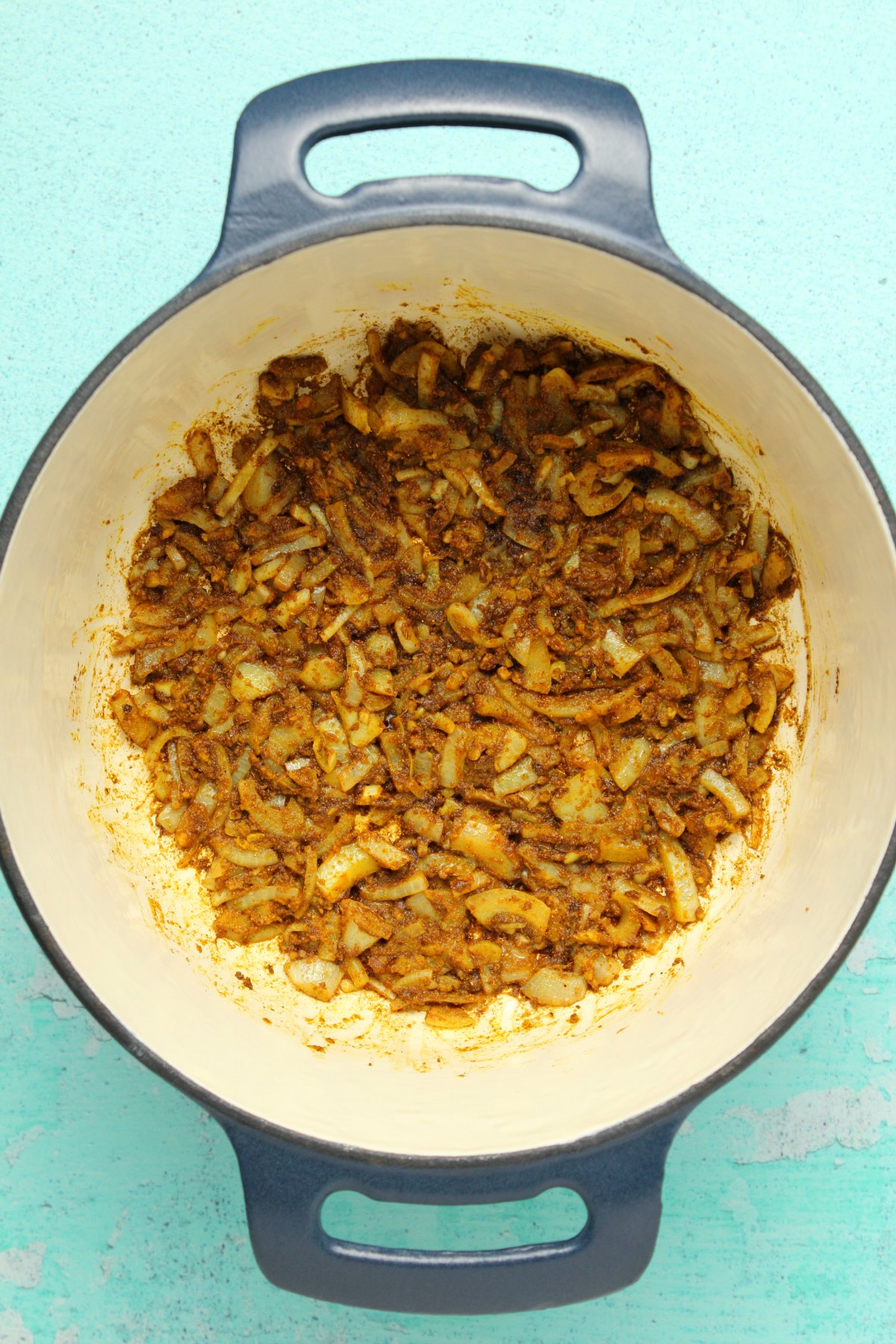 Sautéed onions and spices in a pot.